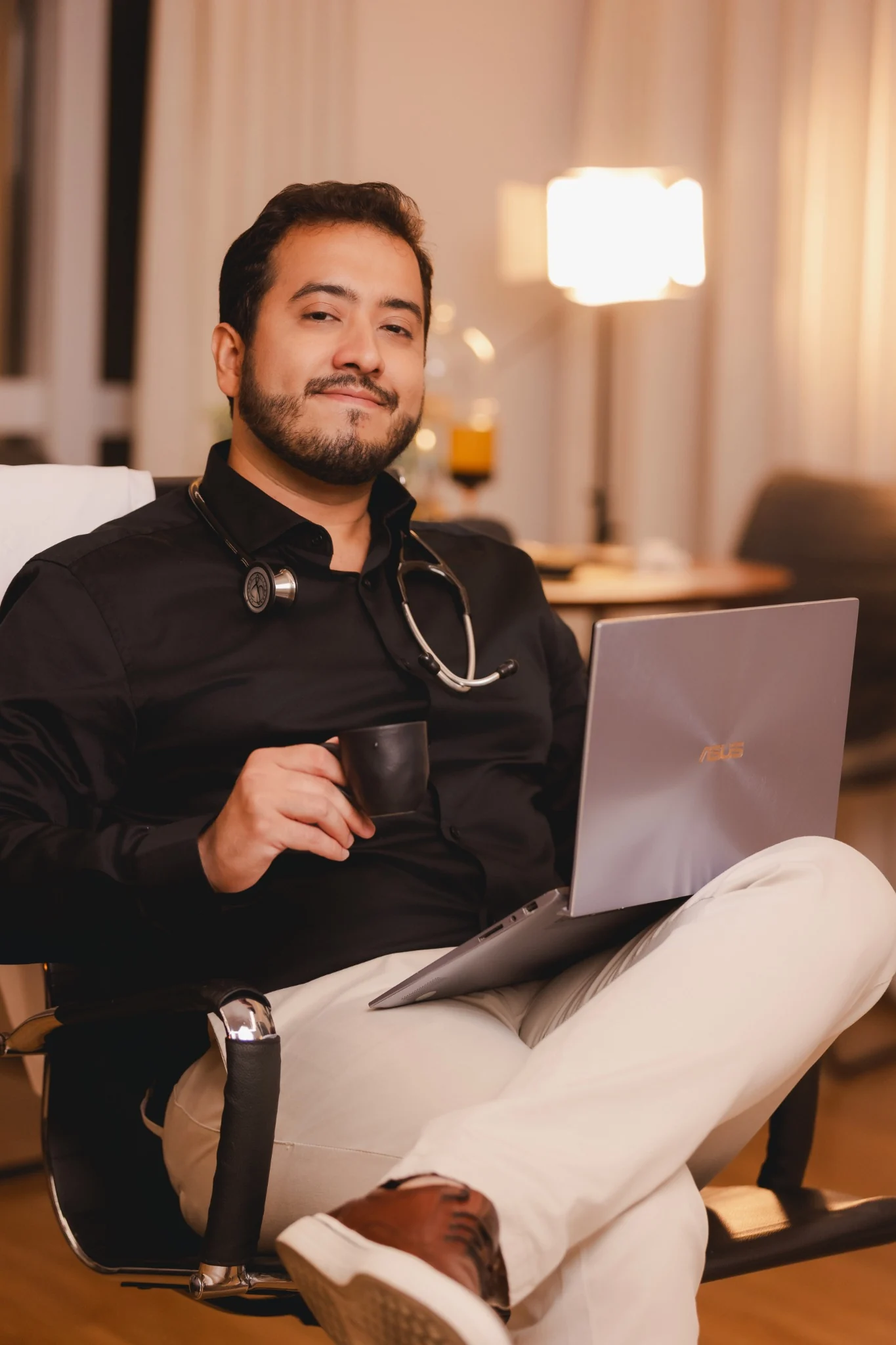 Dr. Lucas Valverde Rocha sentado com uma xícara de café e um notebook